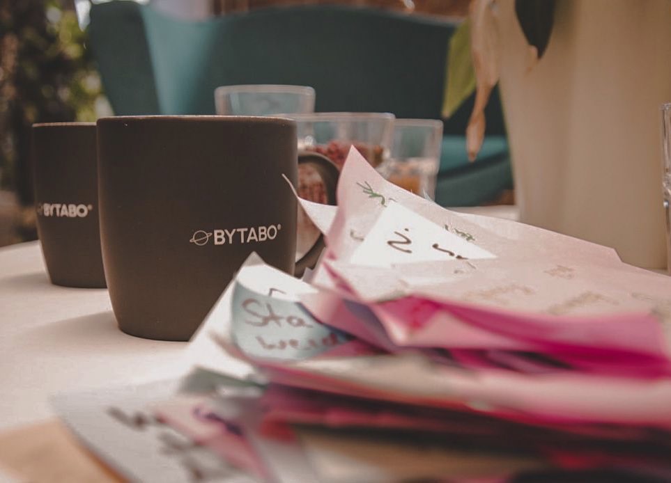 ein bunter Stapel Postits vor einer schwarzen Tasse